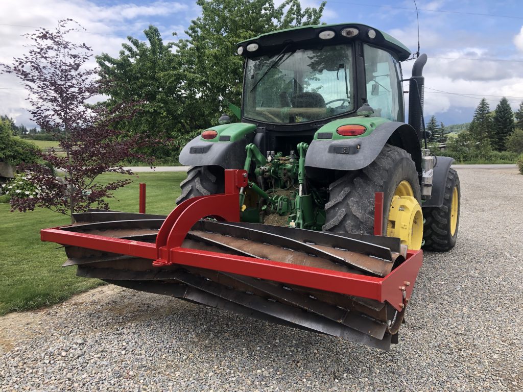A tractor with a spinning metal plough attachment.